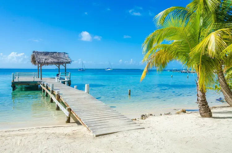 Pier on small tropical island at Barrier Reef with paradise beach - known for diving, snorkeling and relaxing vacations.