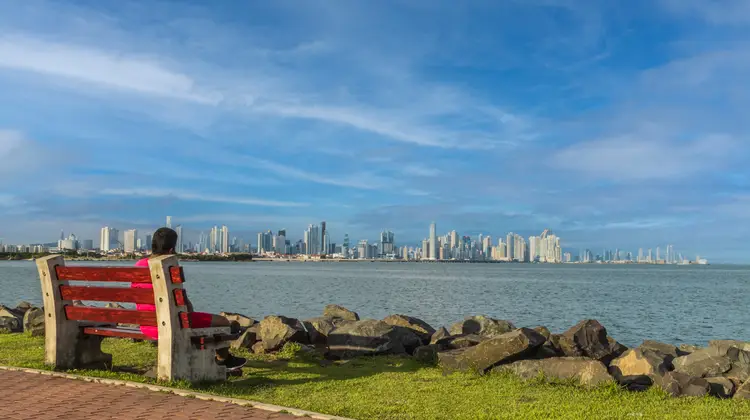 Woman sitting on a bench looking at the horizon